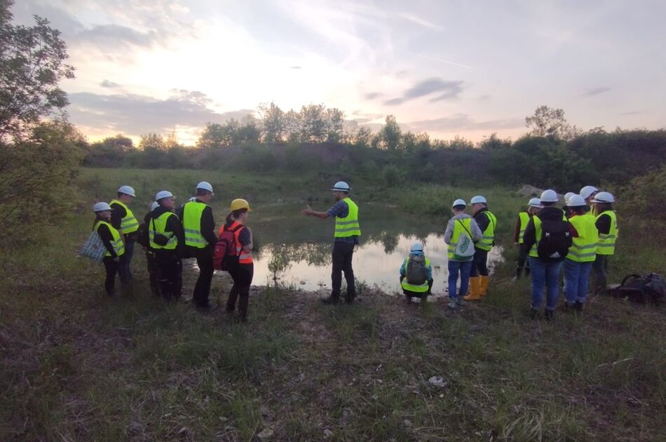 Teilnehmende während der Nacht der offenen Grube mit Schutzhelm an einem Teich